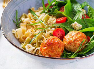 Italian pasta. Pasta  with meatballs,  cheese and fresh salad on light background. Dinner.  Slow food concept