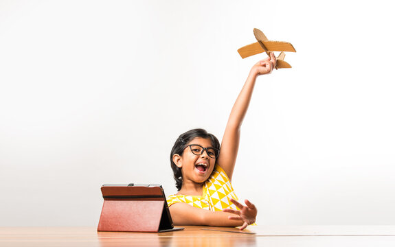 Cute little Indian girl making Paper plane, aeroplane for science project with online tutorial