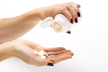 white pills in white plastic jar. COVID-19. Medical mask on a hand with white background. Medicine pills or Vaccine against the virus.