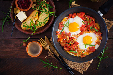 Late breakfast - fried eggs with vegetables. Shakshuka. Arabic cuisine. Kosher food. Top view