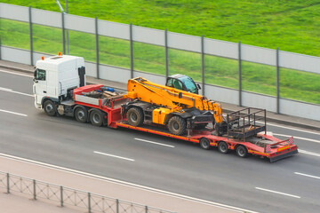 Truck with a trailer platform transports equipment with an elevator car platform, hydraulic and...