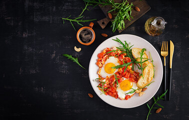 Late breakfast - fried eggs with vegetables. Shakshuka. Arabic cuisine. Kosher food. Top view