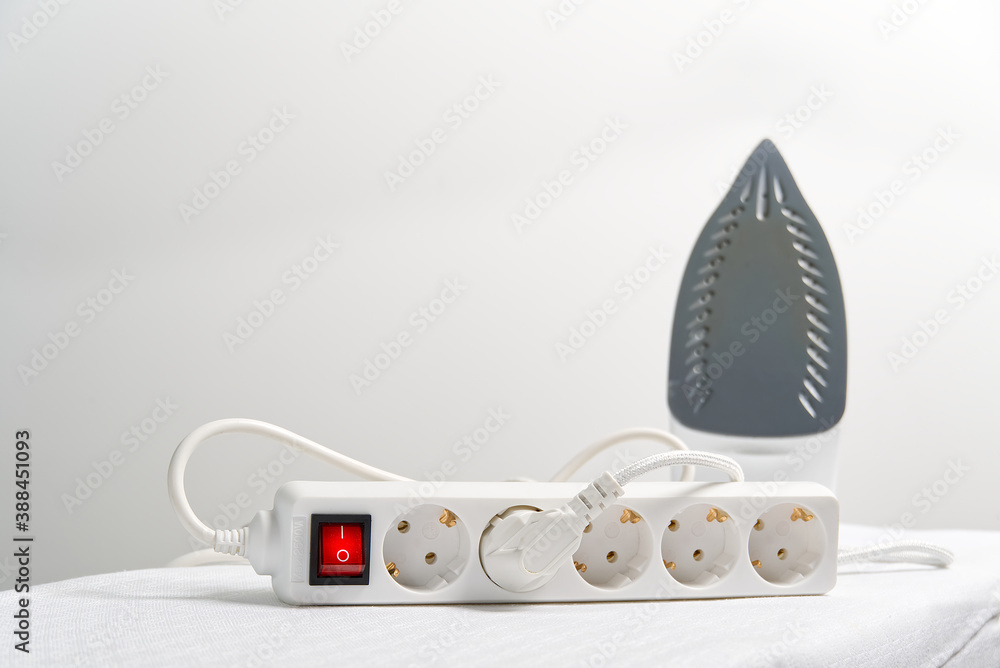 Poster powered iron in extension cord with copy space. electrical extension cord with overload protection.