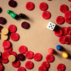 Board games square frame, a flat lay with various pieces and a die, with a place for text on a brown background