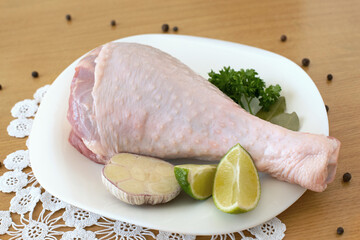 aw leg of turkey cutting board with limes and parsley on a white background, isolate..