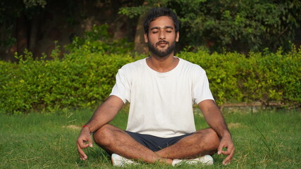 Naklejka na ściany i meble person sitting on grass man doing yoga- Man Doing Meditation in Park - Meditation Images Indian Image