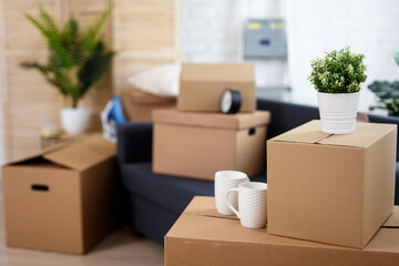 moving day concept - close up of belongings packed in cardboard boxes