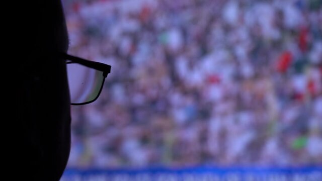 A man with glasses looks at the screen. A huge amount of information for a person through the media. Correct Glasses on Eyes.