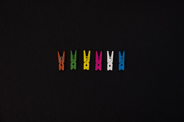 Colored wooden pegs on black background, Diversity or choice concept with copy space