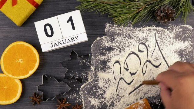 making an inscription on the flour 2021. preparing festive treats for Christmas and new year holidays.  calendar with the date January 01. flat layout. cookie molds and flour. 