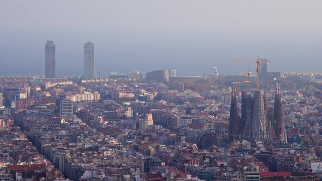 view of polluted barcelona city from bunkers viewpoint. sagrada familia cathedral and mapfre towers highlighted. famous mediterranean destination in catalonia spain