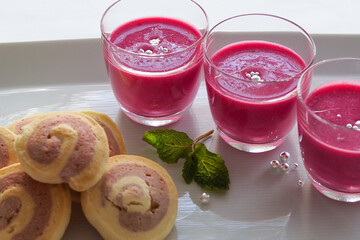 Cold beet soup and beet cookies on white dish, white background
