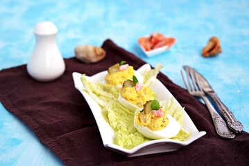 Cold appetizer, stuffed eggs with shrimps and pickled cucumber