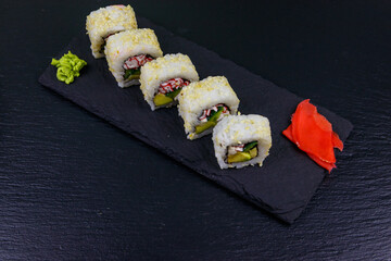 Uramaki sushi rolls with surimi on a black slate