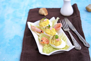 Cold appetizer, stuffed eggs with shrimps and pickled cucumber