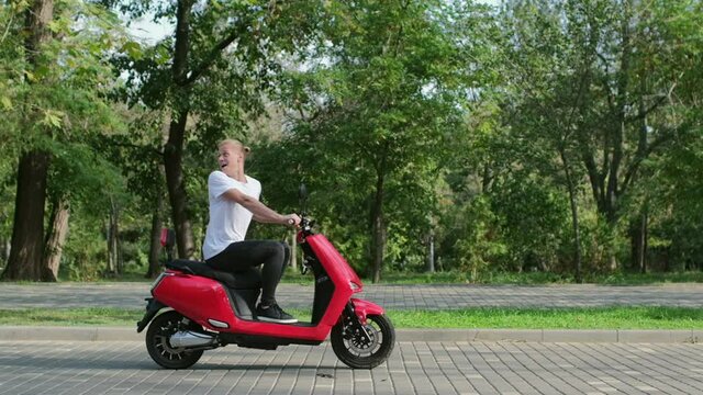 A man with a bouquet of flowers runs after a young guy on a red moped leaving him. Flower delivery right in your hands. 