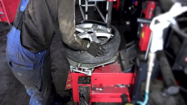 repairman work with wheel tire on balancer at repair service. 4K