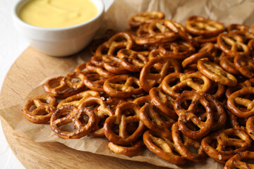 Tasty cracker pretzels and cheese sauce on white background