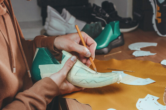 Shoemaker drawing a pattern on the shoe model