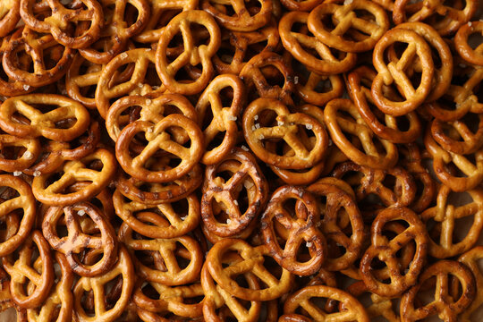 Tasty salty cracker pretzels on whole background