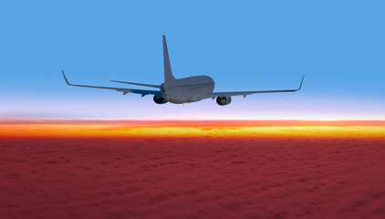 White passenger airplane over the clouds at sunset - Travel by air transport