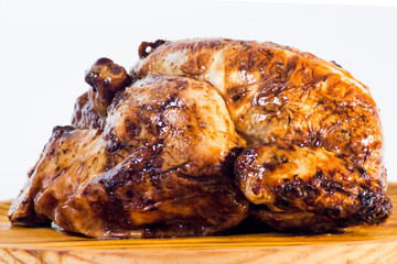 Roast chicken on a wooden tray on white background
