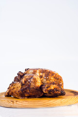 Roast chicken on a wooden tray on white background