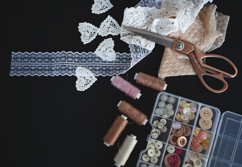 a stack of fabrics and sewing accessories on a tailor's table