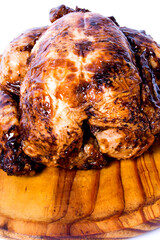 Roast chicken on a wooden tray on white background