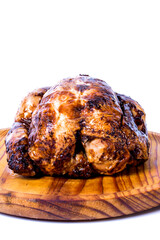 Roast chicken on a wooden tray on white background