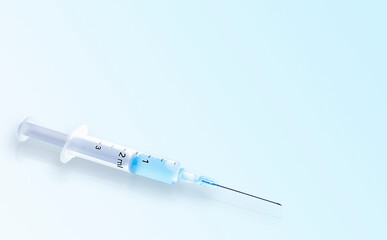 syringe with medicine on a light blue background