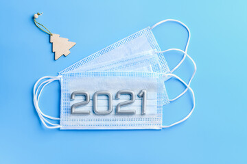Three medical masks and numbers 2021 on a blue medical background. Concept of the protection against coronavirus, 2019-nCoV