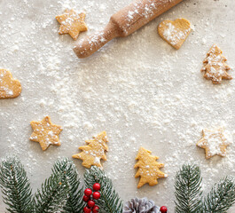 Christmas layout with spruce branches berries cones gingerbread in the form of Christmas trees stars hearts and a rolling pin with flour