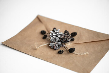 Obraz na płótnie Canvas Craft envelope for greeting card with Christmas decoration made of pine cones