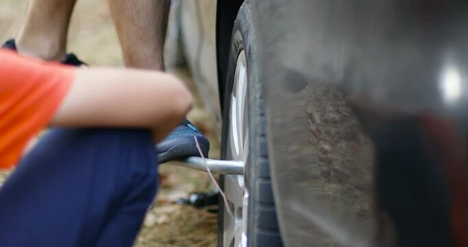Replace a broken tire with a special tool. Man changing tires on the car