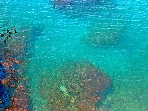 Turquoise blue clear glittering ripples sea surface background .