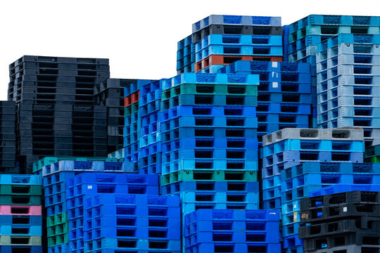 Pile of plastic shipping pallet isolated on white. Industrial plastic pallet stacked at factory. Cargo and shipping. Plastic pallet rack for export delivery industry. Plastic pallet storage warehouse.
