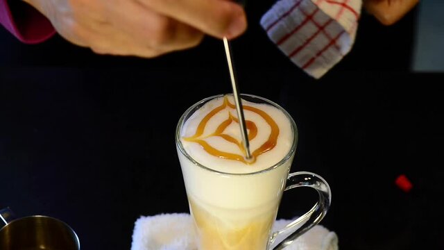 Coffee decoration. 
Caramel art on milk foam of latte coffee ,hd video.