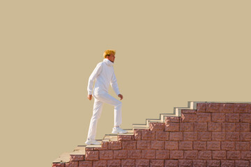 A young man dressed in white climbs the stairs to the top.