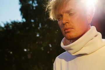 A young man with sadness and thoughtfulness, looks down. Close-up.