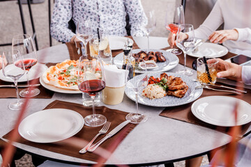Served table for dinner. Group of friends enjoying meal at outdoor restaurant