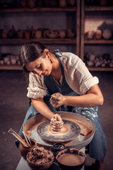 Charming ceramist making ceramic pot on the pottery wheel . Concept for woman in freelance, business, hobby.