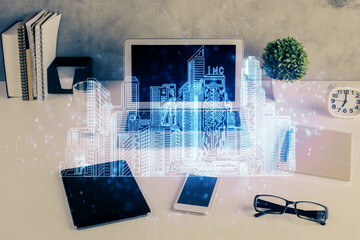 Desktop computer background in office and big town buildings hologram drawing. Double exposure. Smart city concept.