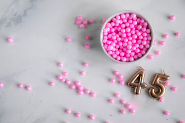 Pink balloons on a white background and in a white Cup with numbers for birthday cake