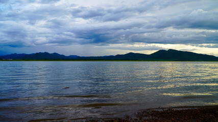 sunset in the evening with a vast reservoir and mountains