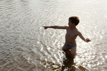 Fototapeta premium child playing on the beach by the water