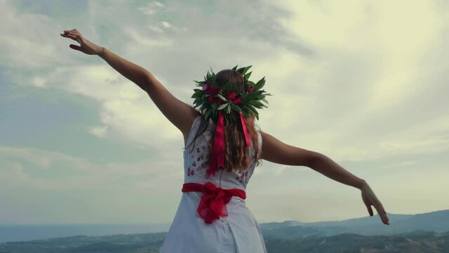 Giovane ragazza con vestito bianco si laurea. Corona di alloro in testa simbolo trionfale italiano.