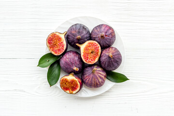 Fresh figs in on a plate with green leaves. Top view
