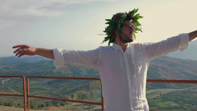 Giovane ragazzo laureato con corona di alloro in testa festeggia il suo traguardo