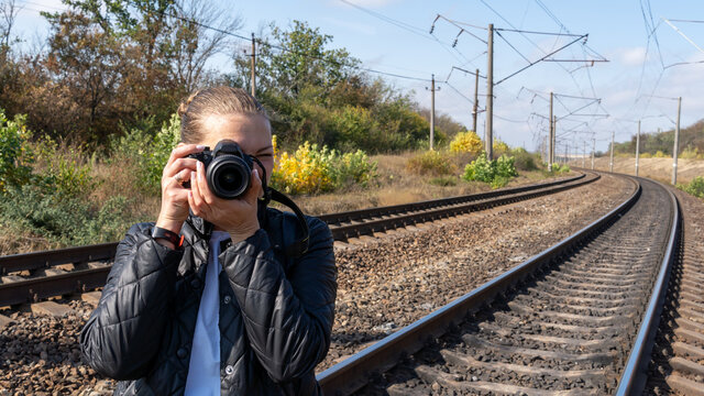 Woman on the railway taking pictures of the nature